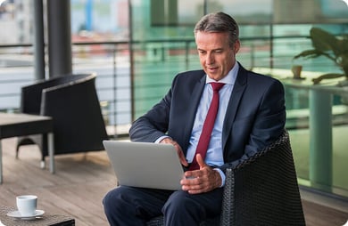 Professional client advisor on a chair using his laptop. 