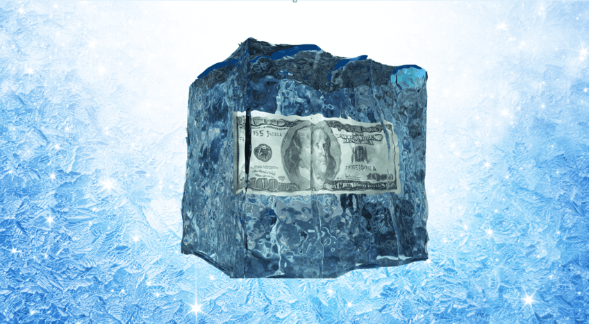 a large blue ice cube with a $100 bill inside