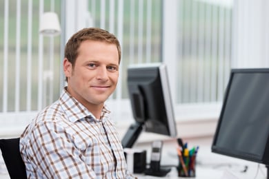 portrait man smiling at desk checked shirt Marc D.