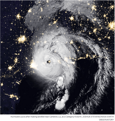 NASA satellite image of hurricane clouds over night time city lights.