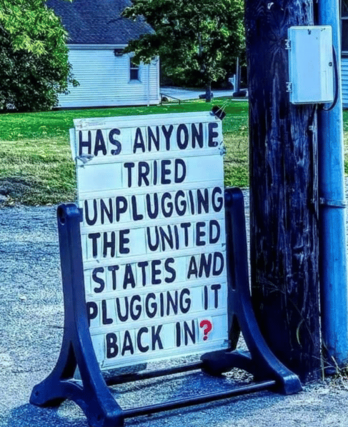 sign on sidewalk says "has anyone tried unplugging the U.S. and plugging it back in?"
