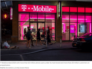 photo of T-Mobile store at night with red neon sign lights
