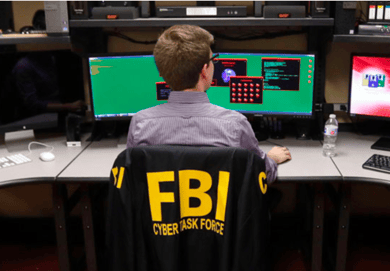 FBI agent sitting at computer screens