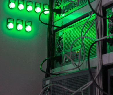 computers on racks with green lights mining crypto