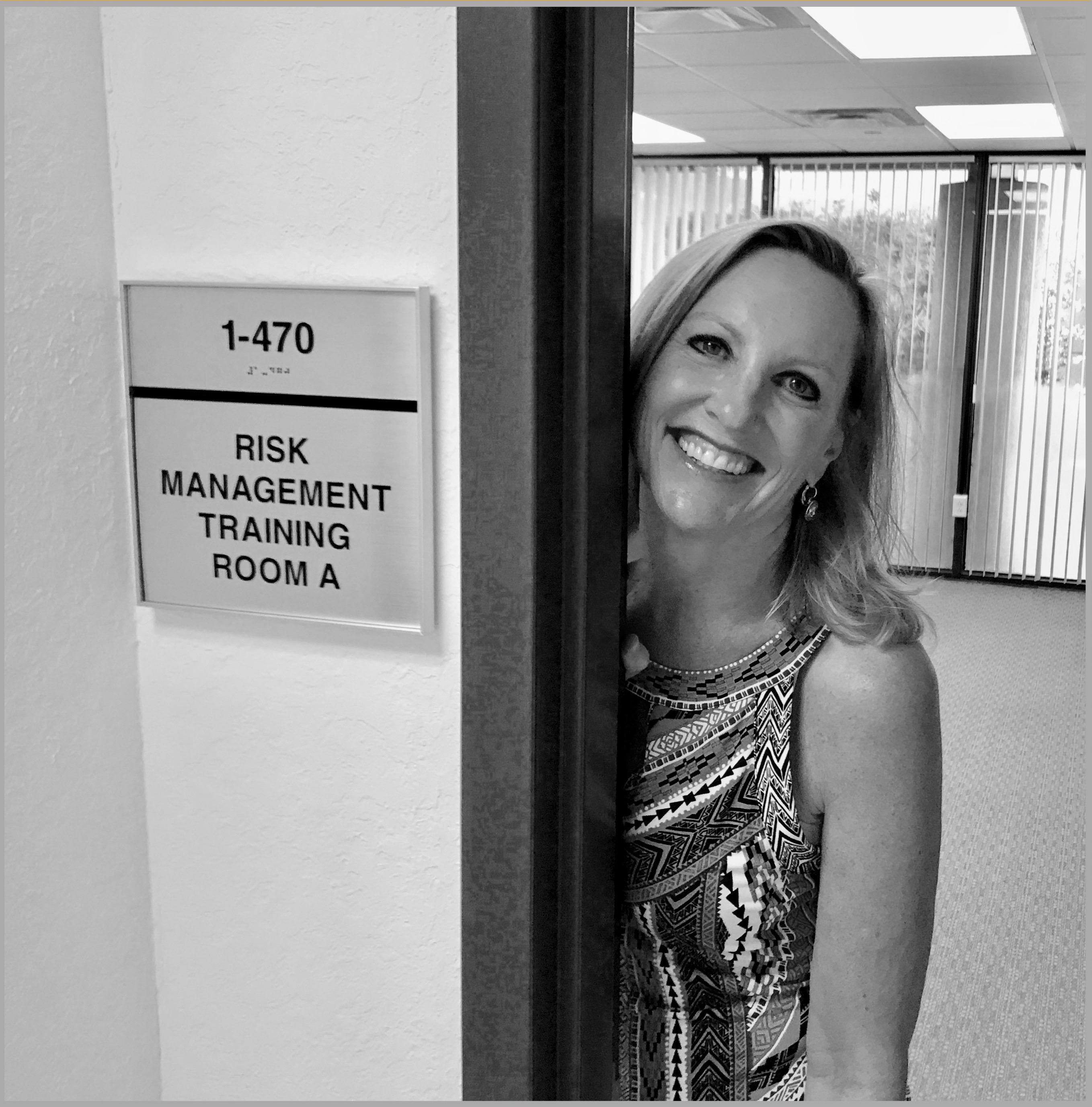 smiling woman at conference room door for cyber rick management training