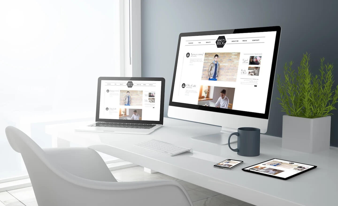 grey studio office with digital devices and a black coffee cup