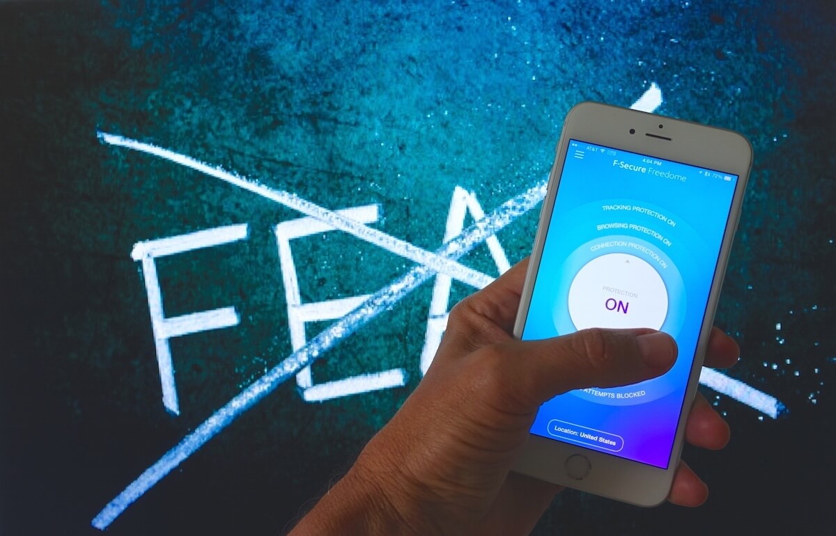 blue background with white letters spelling a crossed-out X over F-E-A-R and an iPhone VPN