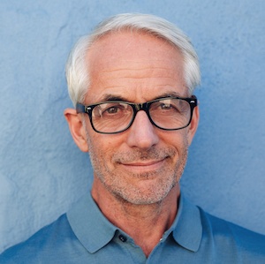 smiling man white hair blue shirt portrait