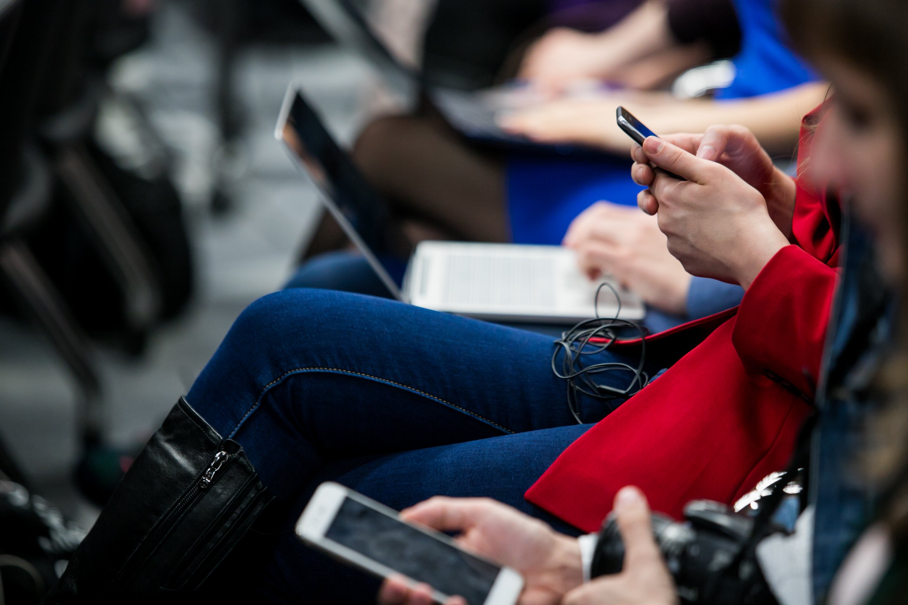 women in red on device at seminar